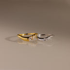 Gold and silver curve rings with marquise cut stones, designed in a sleek wavy silhouette for stacking or standalone wear.