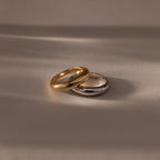 The Mixed Metal Dome Ring Set—featuring a gold and a silver ring side by side on a smooth surface with soft lighting—captures modern style and versatility, making it the perfect jewelry choice for any occasion.