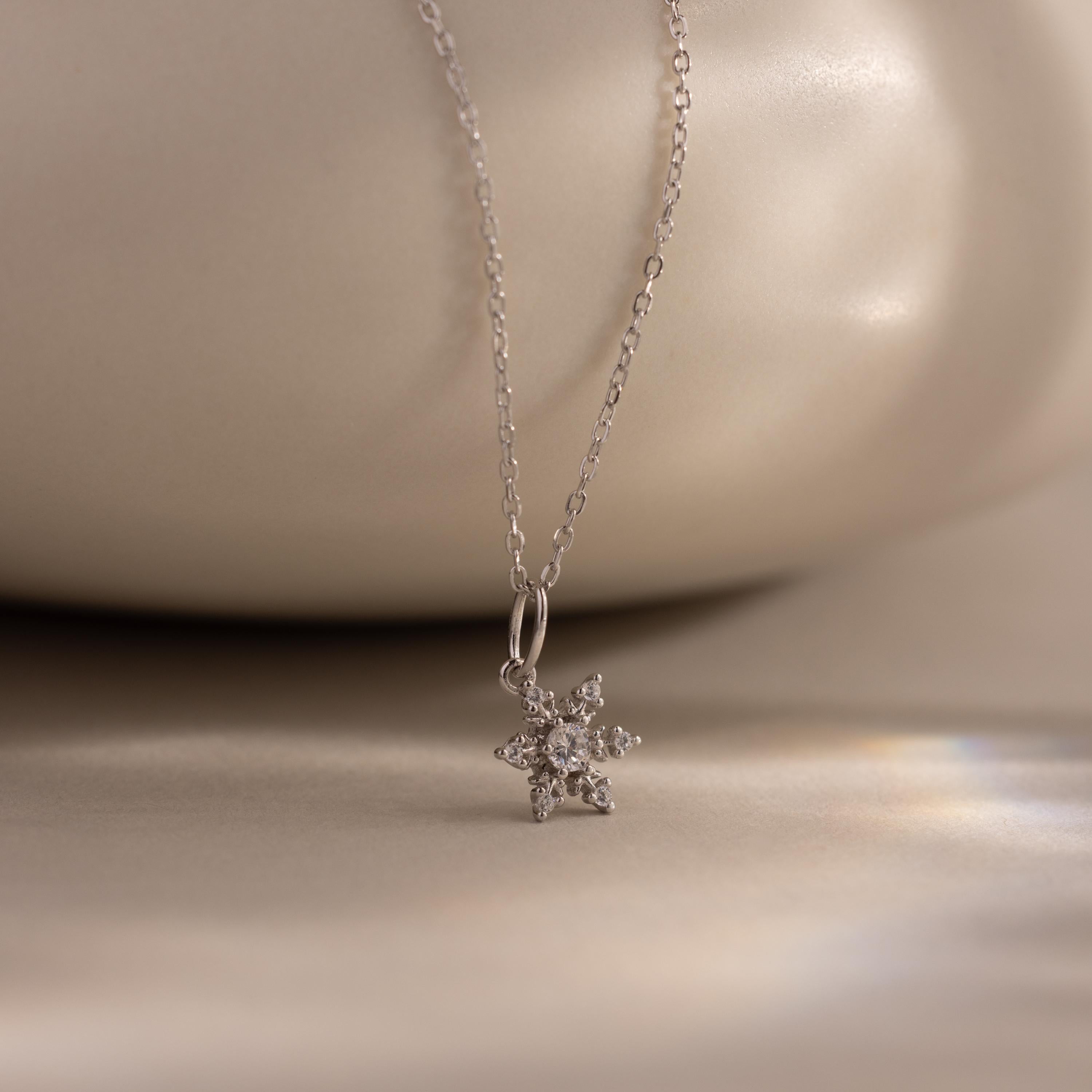 Flatlay of our Diamond Snowflake Necklace against a white bakground