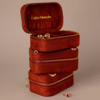 The Cherry Red Velvet Jewelry Case features gold zippers; one is open, revealing organized rings and earrings—an ideal luxury storage solution for your jewelry.