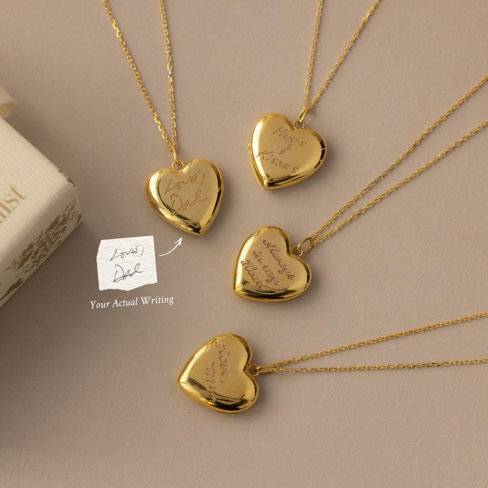 Flatlay of our Engraved Heart Locket Necklace in 18K Gold with a handwriting reference photo