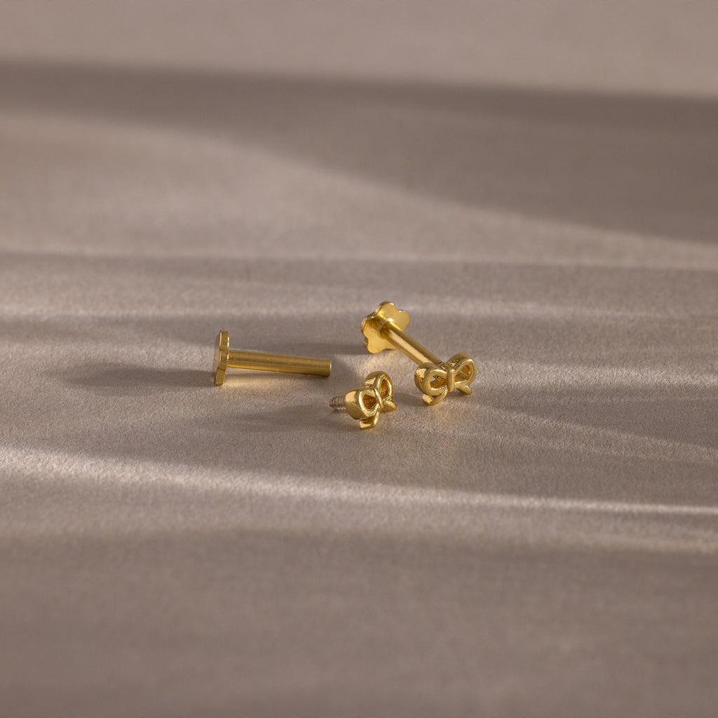 Flatlay showing our Tiny Bow Flatback Studs in 18K Gold with the flatback posts separated