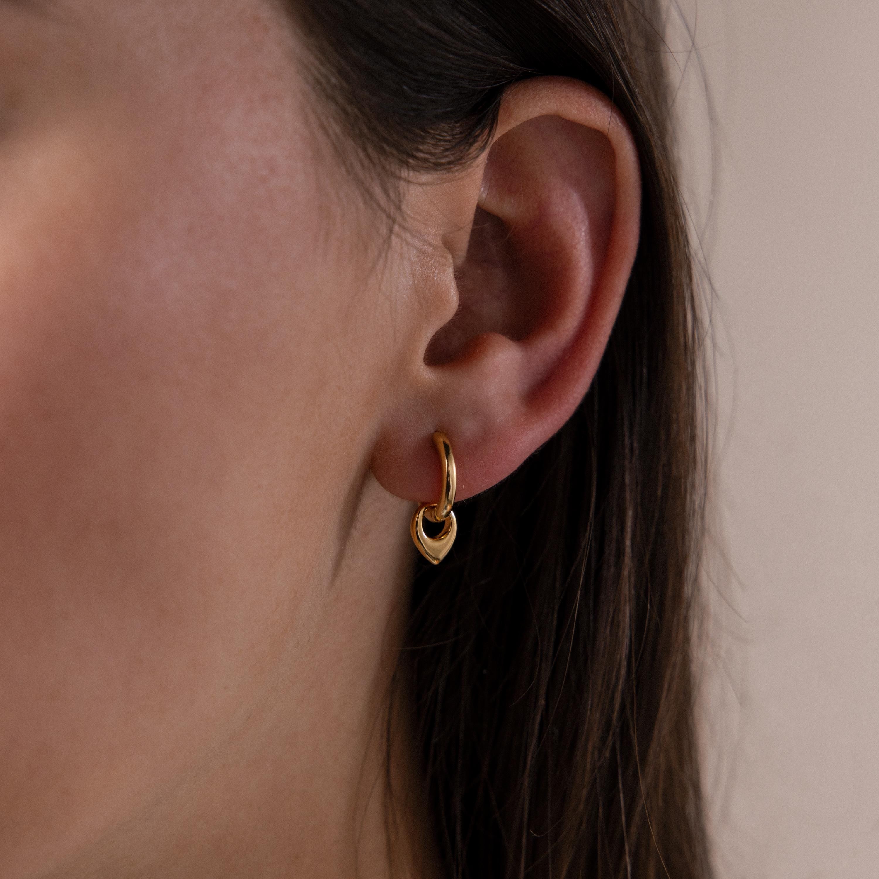 Close up of a model wearing our Tiny Teardrop Huggies in Gold