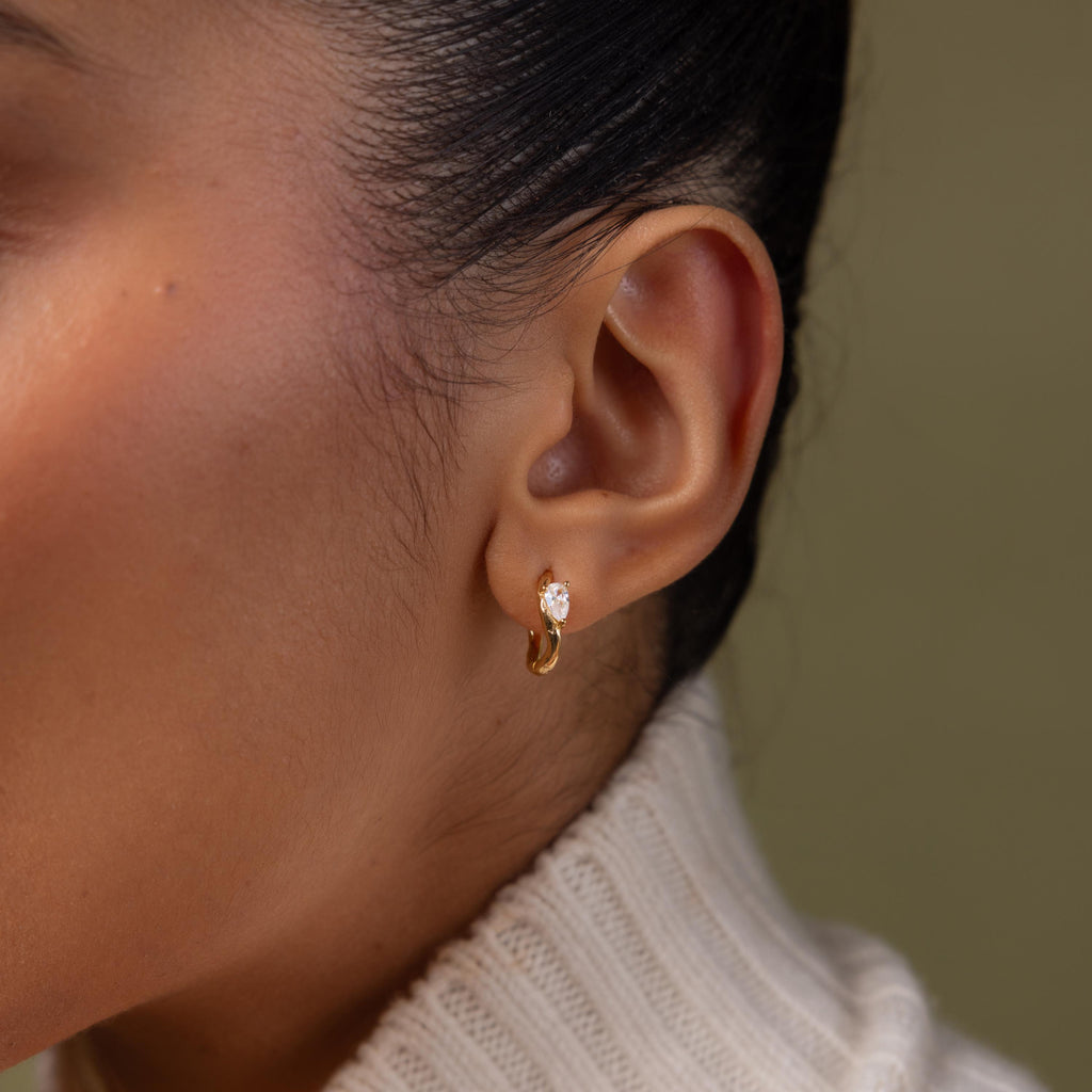 Close up of a model wearing our Hammered Diamond Teardrop Hoops in Gold