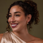 Model wearing our Holiday Tree Studs earrings against a green background
