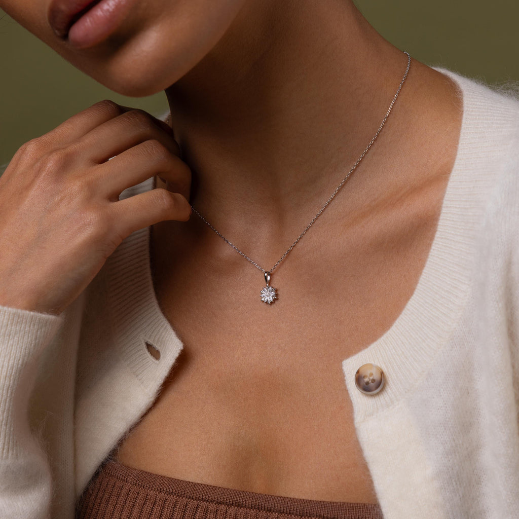 Close-up of a model wearing our Diamond Poinsetta Pendant Necklace in Silver