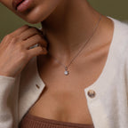 Close-up of a model wearing our Diamond Poinsetta Pendant Necklace in Silver