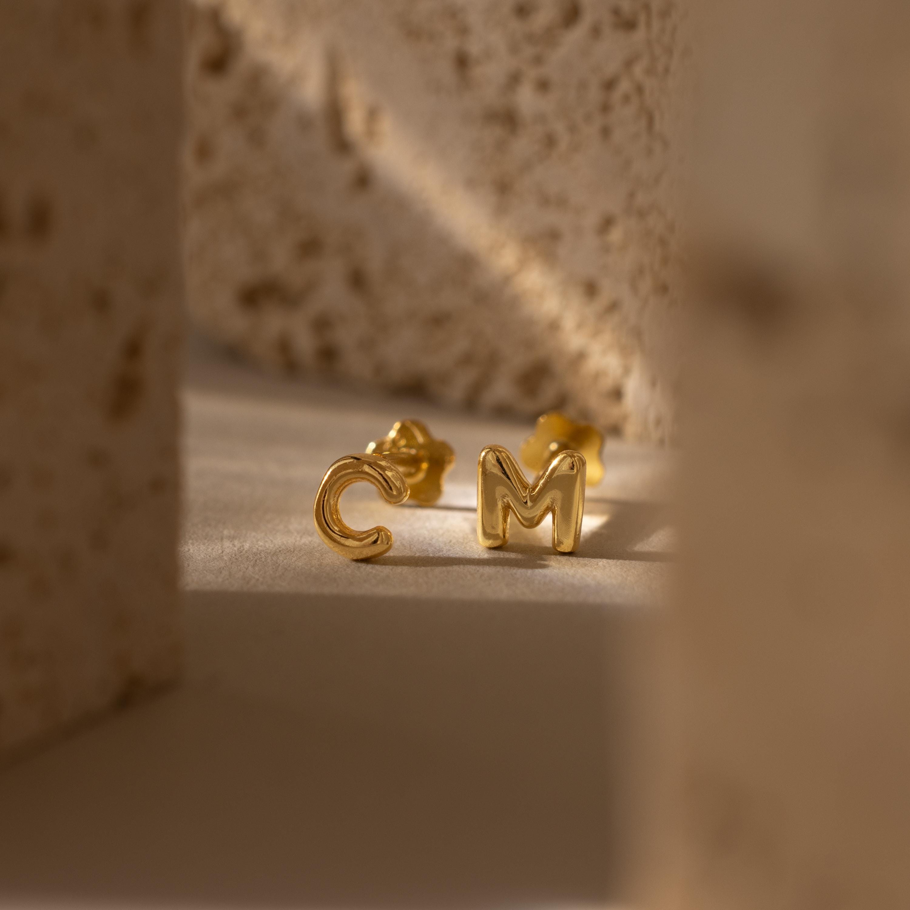 Close up of our Bubble Initial Flatback Studs, featuring letters C & M