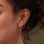 Close-up of a model wearing our Opal & Star Duo Chain Studs, styled with our North Star Flatback Studs and Pave Opal Star Huggies