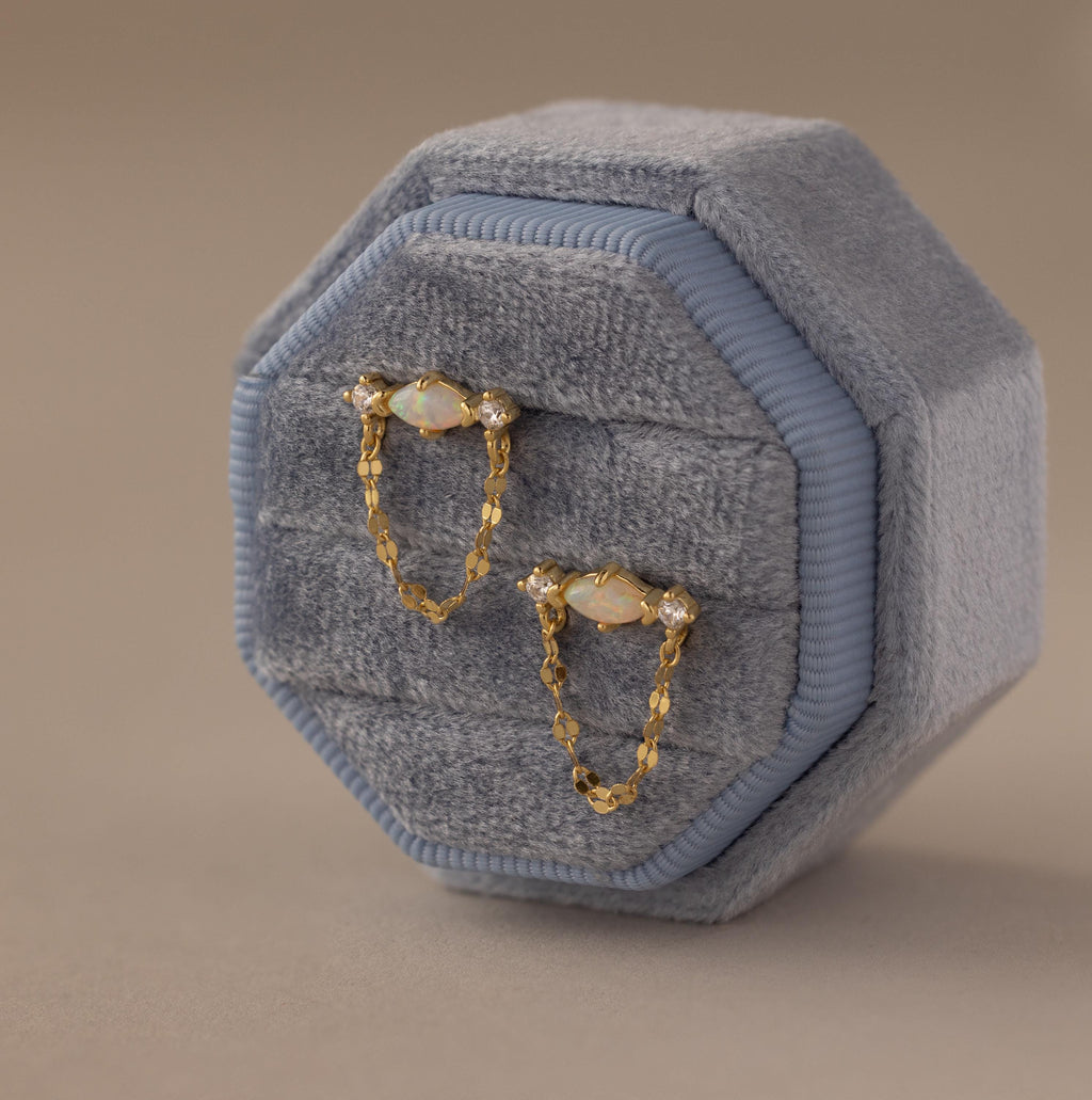 Flatlay of our Opal & Diamond Chain Studs in a Blue Velvet Jewelry Box