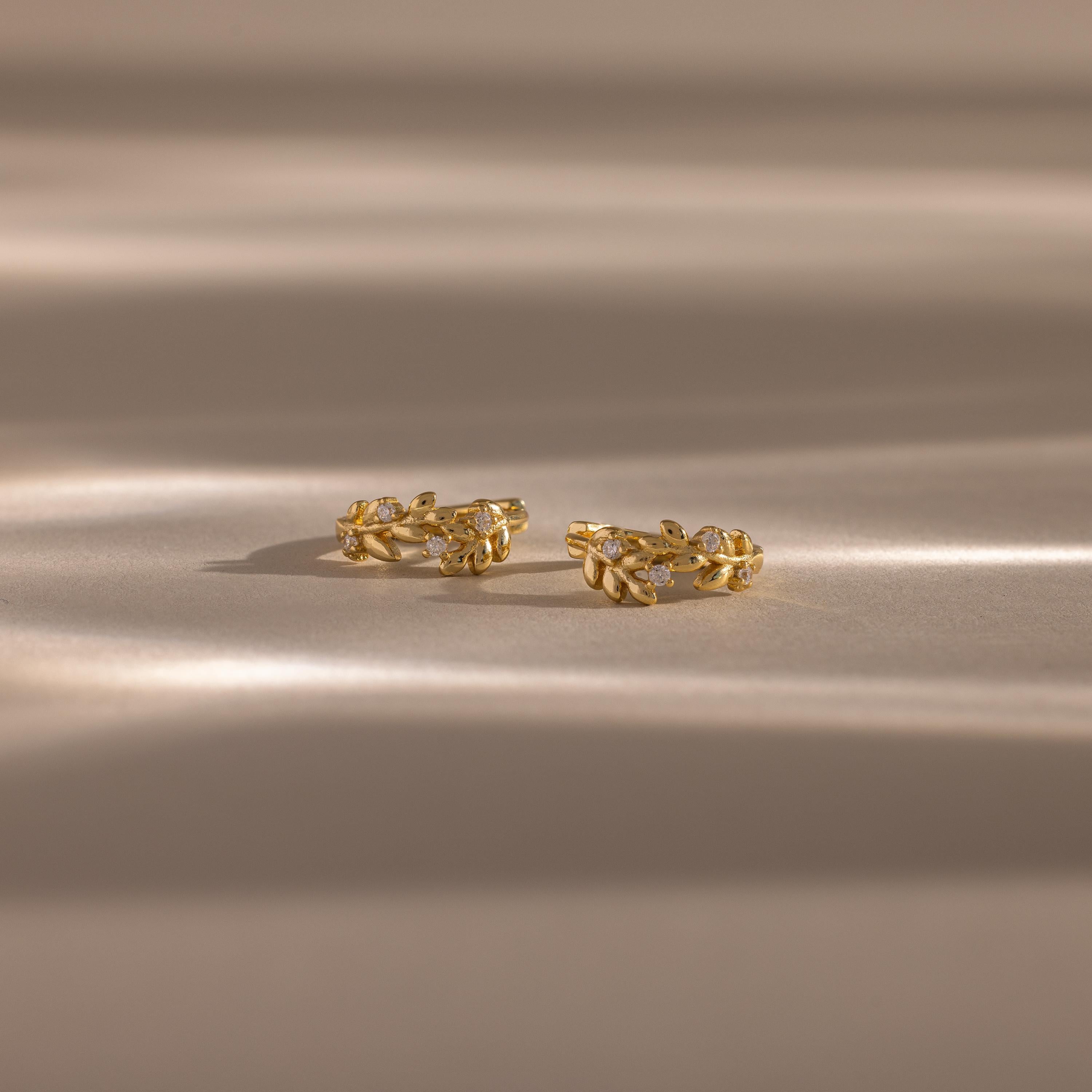 Close up flatlay image of our Diamond Leaf Hoops in 18K Gold