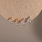 Two pairs of our Lace Diamond Hoops in Gold and Silver on a beige background