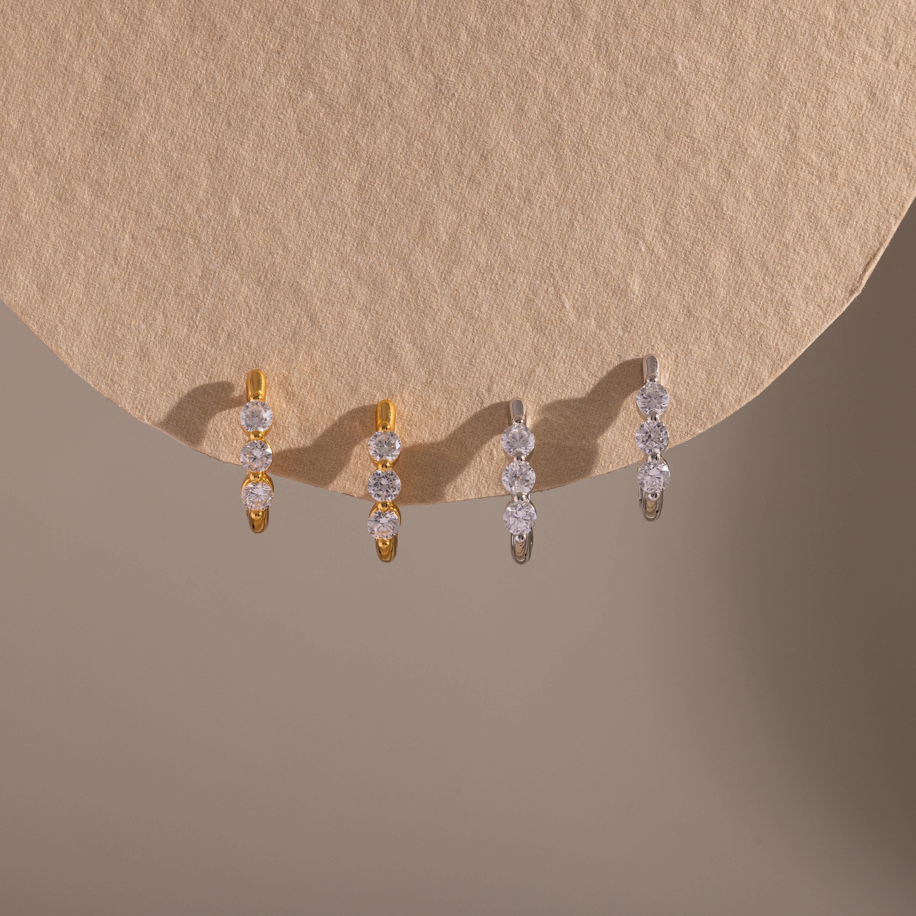 Two pairs of our Lace Diamond Hoops in Gold and Silver on a beige background