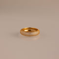 The Bold Pave Stacking Ring, encrusted with small diamonds, gleams on a reflective beige surface.