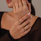 A woman's hands adorned with the Pave Mixed Metal Linked Ring Set—styled with a sheer black top and light pink manicured nails for a versatile jewelry look.