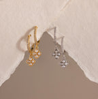 Pave Rounded Pearl Flower Hoops—gold and silver floral drop earrings with pearl centers, perfect as elegant wedding earrings—displayed on a textured off-white paper background.