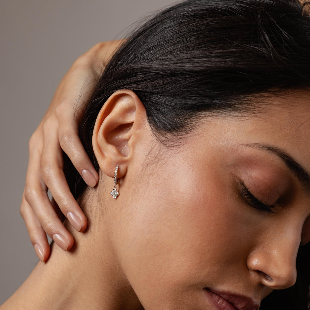 With her eyes closed and hand on her neck, she wears Pave Rounded Pearl Flower Hoops, adding a romantic touch to her look.