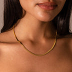 Woman wearing the Bold Snake Chain Necklace, shown from the shoulders up with focus on her neck and collarbone—a modern jewelry essential.