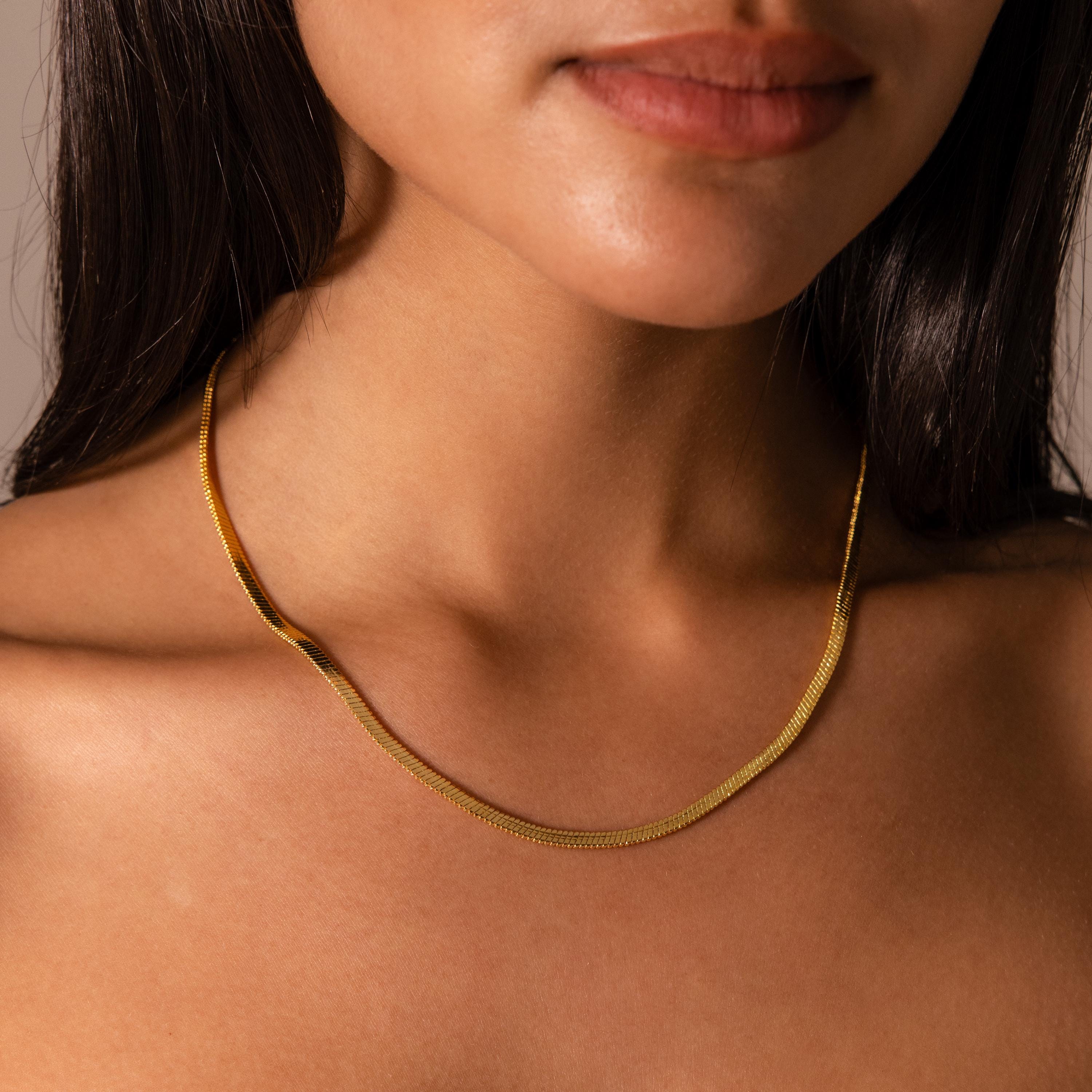 Woman wearing the Bold Snake Chain Necklace, shown from the shoulders up with focus on her neck and collarbone—a modern jewelry essential.