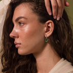 Woman wearing a single Jade Link Drop Hoop earring with a sleek silver chain.