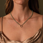 Woman wearing a Beaded Jade Clasp Necklace in Silver with a circular pendant, paired with a satin beige top.