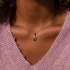 A woman wearing a Ribbed Peridot Pendant Necklace.