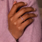 A hand wearing a pink Lace Eternity Ruby Ring rests on a lavender sweater.