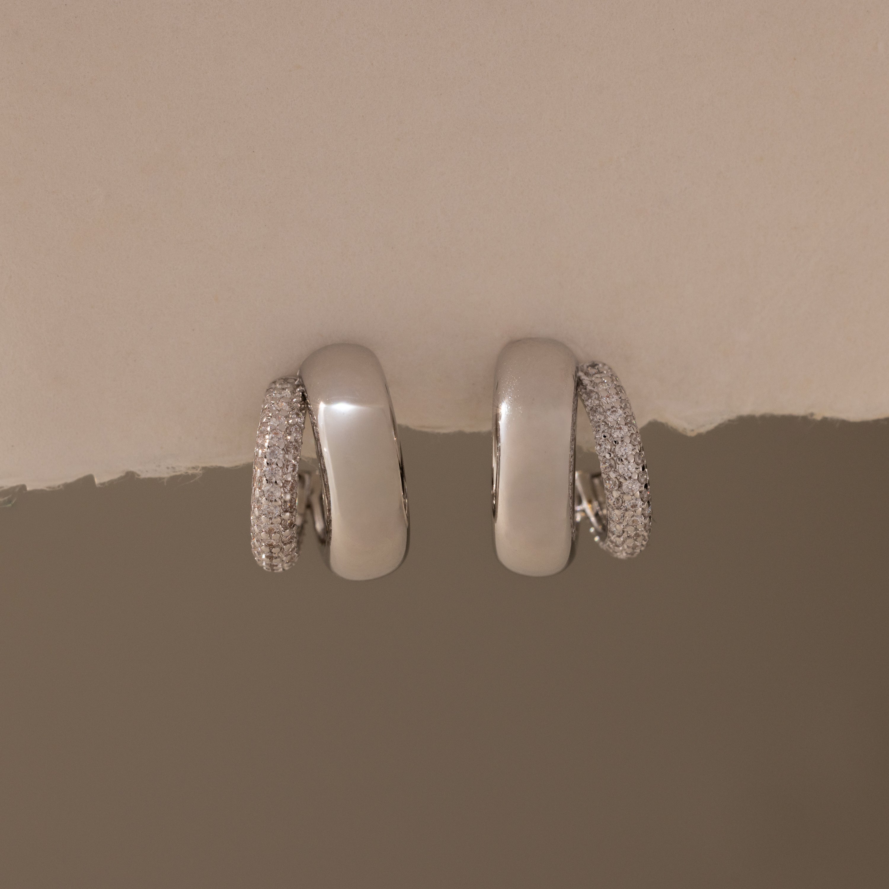 The Duo Pave Dome Studs in White Gold feature one plain and one pavé-encrusted earring, perfect for adding a subtle sparkle to your everyday jewelry collection.