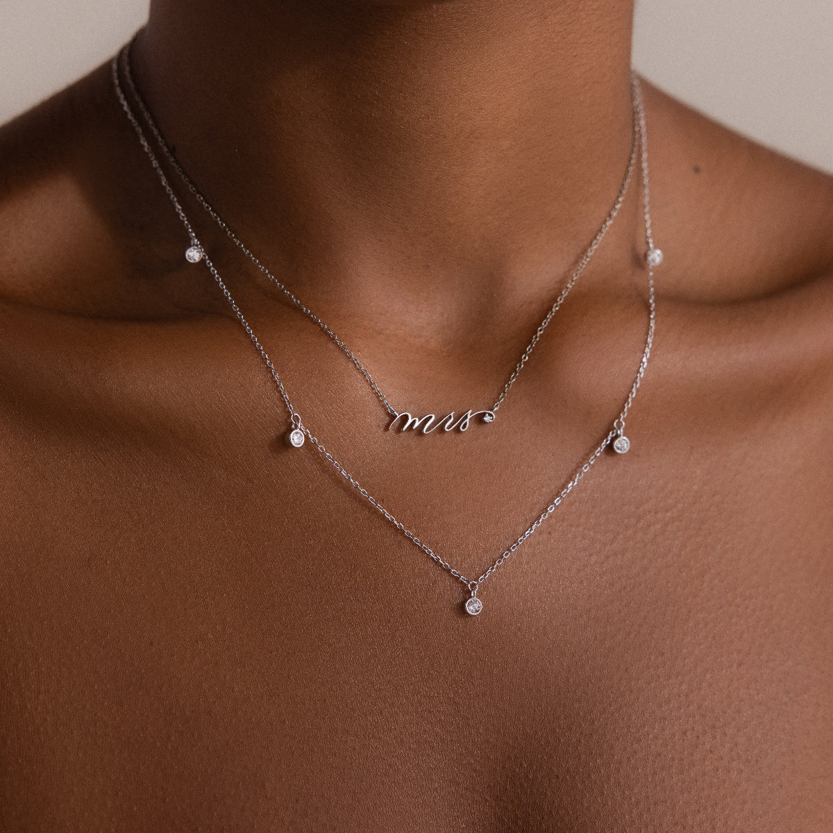 Close-up of a Diamond Station Necklace in Silver on a persons neck, featuring small round pendants—a timeless accessory that brings modern elegance to any outfit.