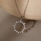 The Pave Sun Necklace in Silver features sparkling diamonds and pave accents on a delicate chain, displayed against a neutral background.