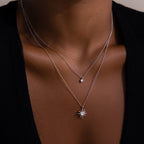 Close-up of a woman’s neck wearing the Laura Starburst Duo Necklace in Silver—two chains, one with a diamond accent and the other with a striking starburst pendant.