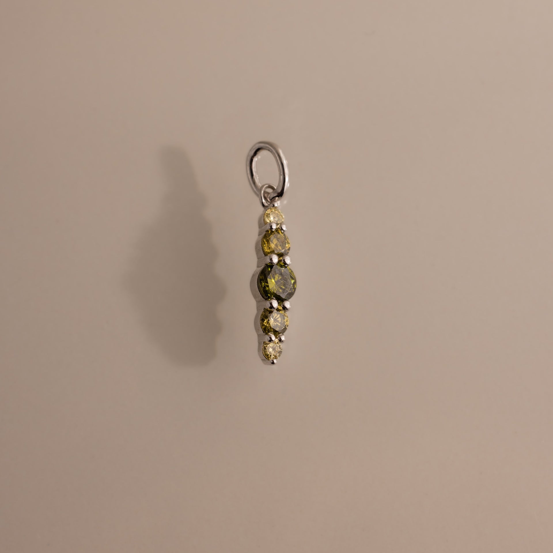 A small Ombre Lace Peridot Charm pendant with five stacked stones and a silver loop on a neutral background.