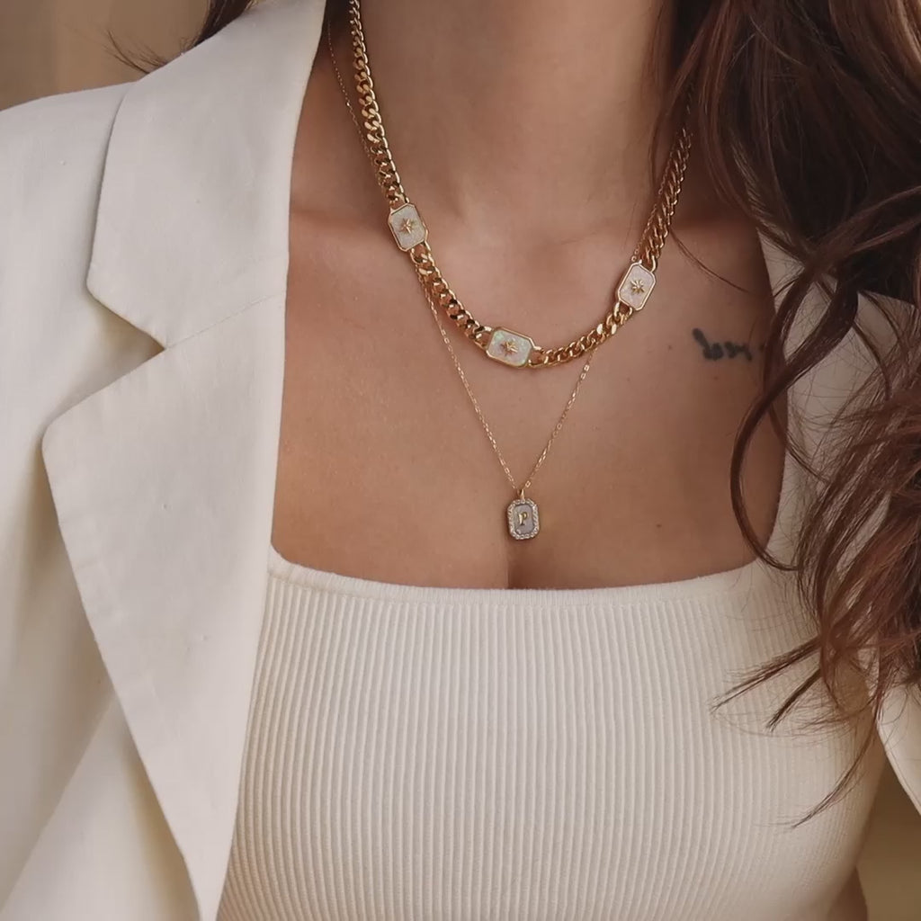 Model wearing a Gold North Star Opal Necklace layered with a Pave Pearl Initial Pendant Necklace.