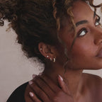 Model showcasing gold Marquise Cluster Hoop Earrings with clustered CZ diamond stones, stacked with multiple gold diamond earrings.