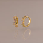 Marquise Cluster Hoop Earrings in gold with clustered CZ diamond stones, shown standing on a soft neutral surface.