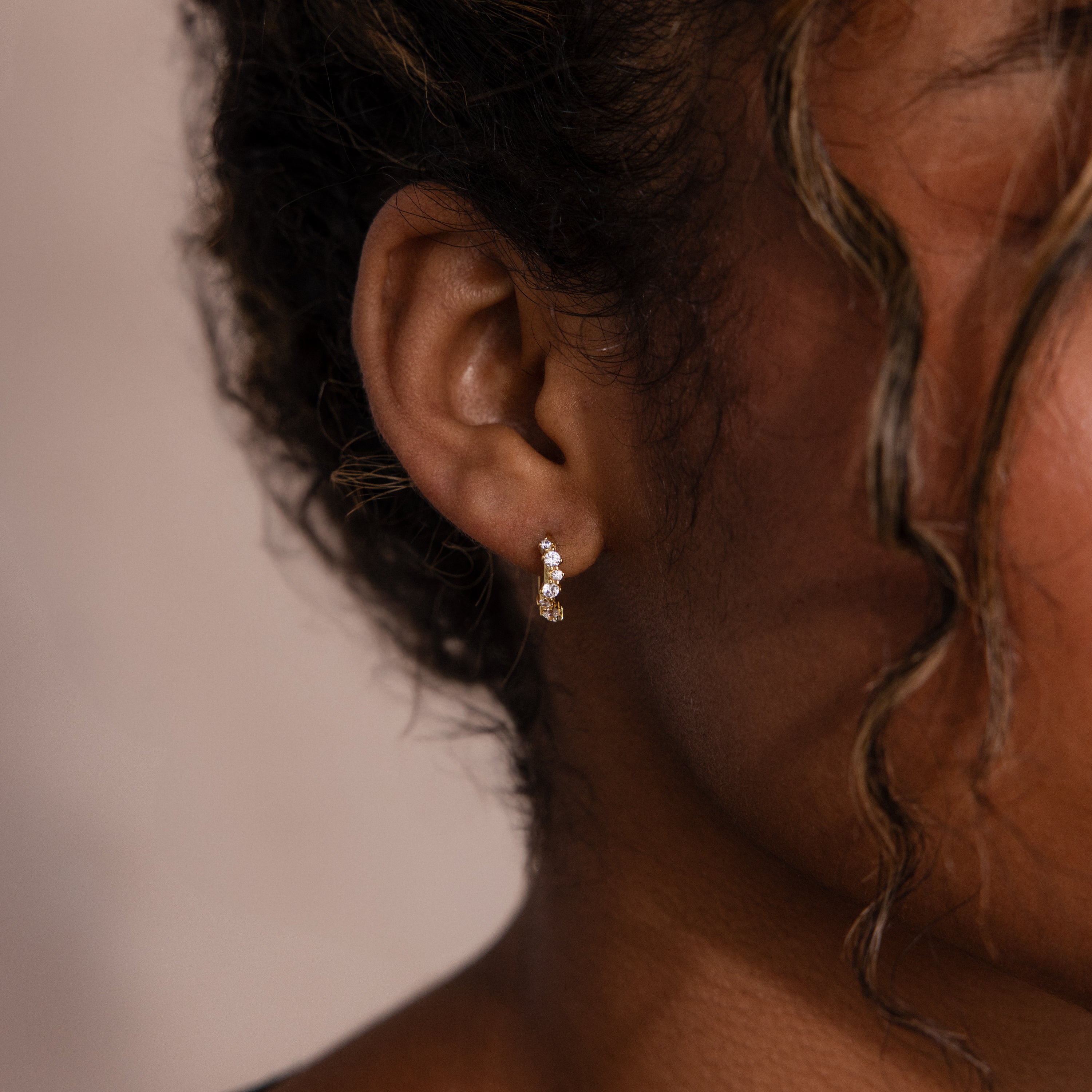 Model wearing Marquise Cluster Hoop Earrings in gold with clustered CZ diamond stones.
