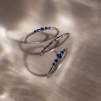 Silver rings with blue gemstones on a textured surface