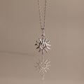 Celestial Sun Necklace in Silver with a spiral sunburst pendant, elegantly set against a soft beige background—a bold statement piece for any style.