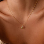 Close-up of the Diamond Seashell Charm Necklace in 18K Gold on a person’s neck, highlighting elegant coastal-inspired jewelry.