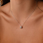 The Diamond Seashell Charm Necklace in Silver features a delicate shell pendant that adds sparkle to a womans neck and collarbone.
