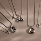 The Dainty Bubble Letter Necklace in Sterling Silver features large A, B, and C pendants with matching small charms—perfect for a personalized, minimalist look against a neutral background. Set includes four necklaces.