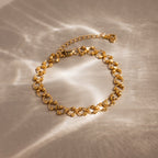 Orbit Chain Bracelet in 18K Gold with textured links on a neutral background, softly lit—an elegant accessory for any occasion.