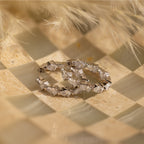 Inside Out Pear Diamond Hoops in Silver, ideal as a bridesmaid gift, showcased on a checkered beige and cream textured background.