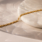 Diamond Chain Tennis Bracelet featuring small diamonds, elegantly displayed on a round marble slab with soft shadows—an enduring piece of jewelry.