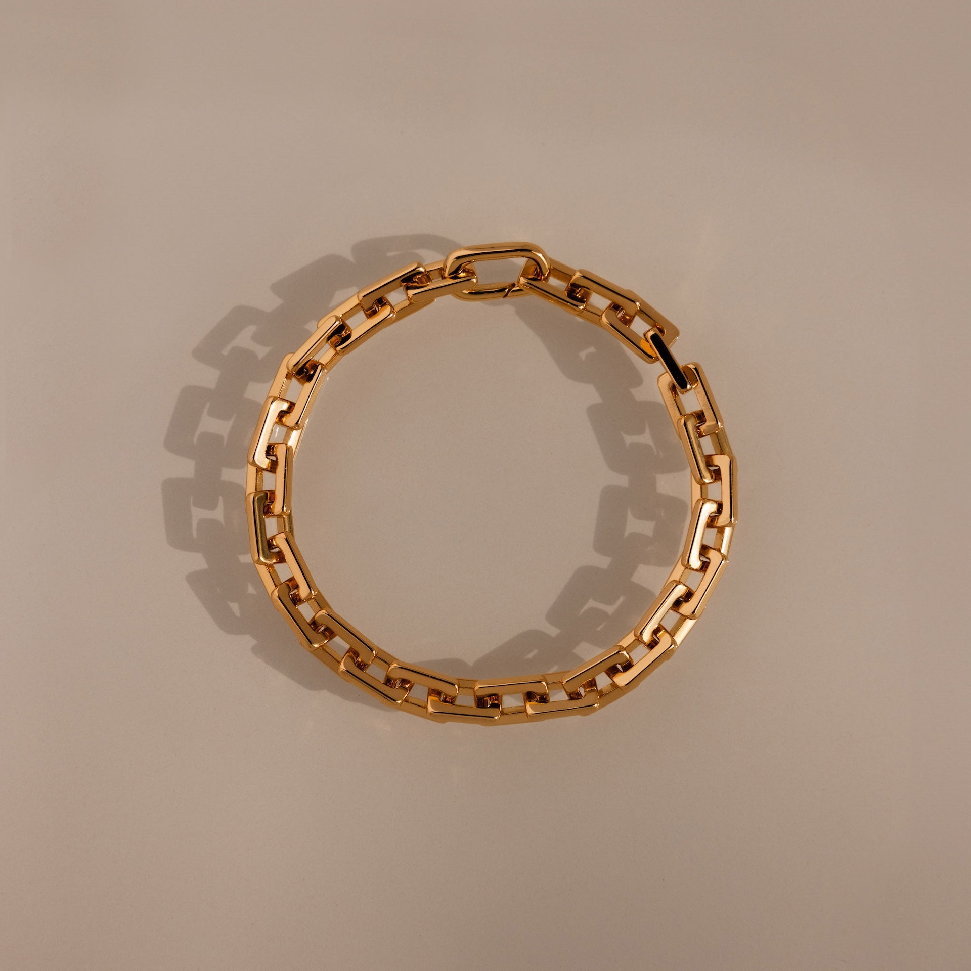 The Eternal Link Bracelet in 18K Gold showcases geometric rectangular links arranged in a circle, making it a modern essential for any jewelry collection.