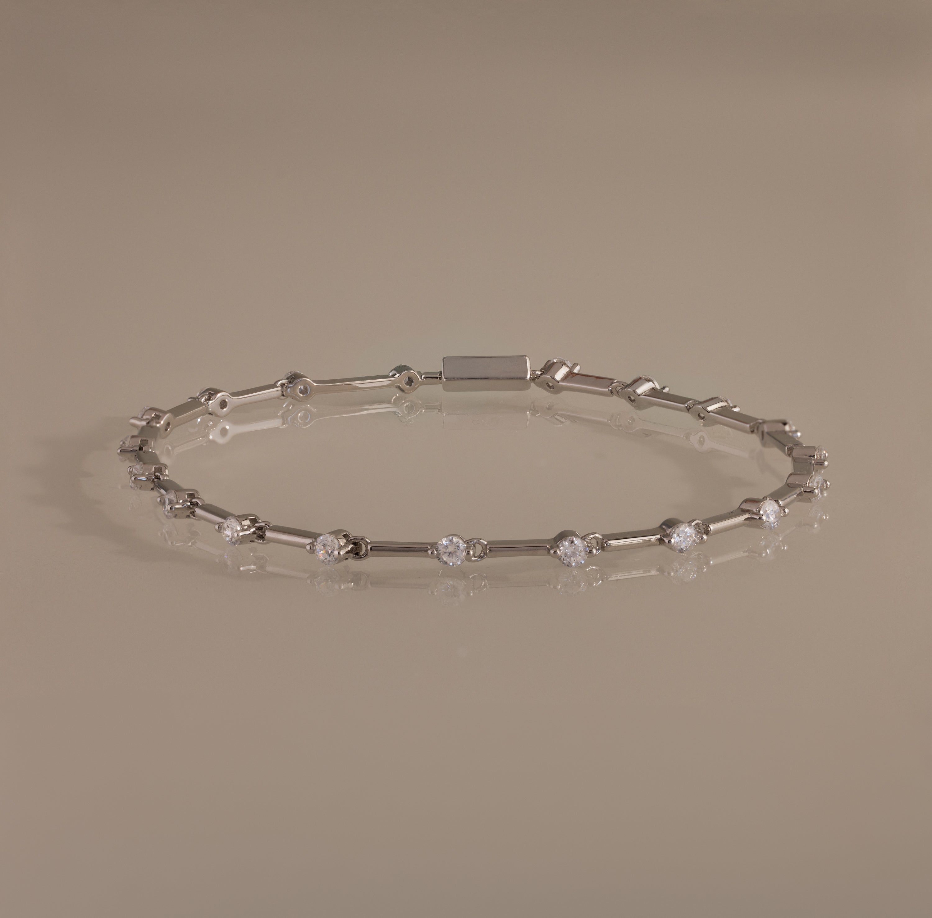 The Sprinkle Diamond Tennis Bracelet in Silver features evenly spaced round diamonds and is displayed on a neutral background.