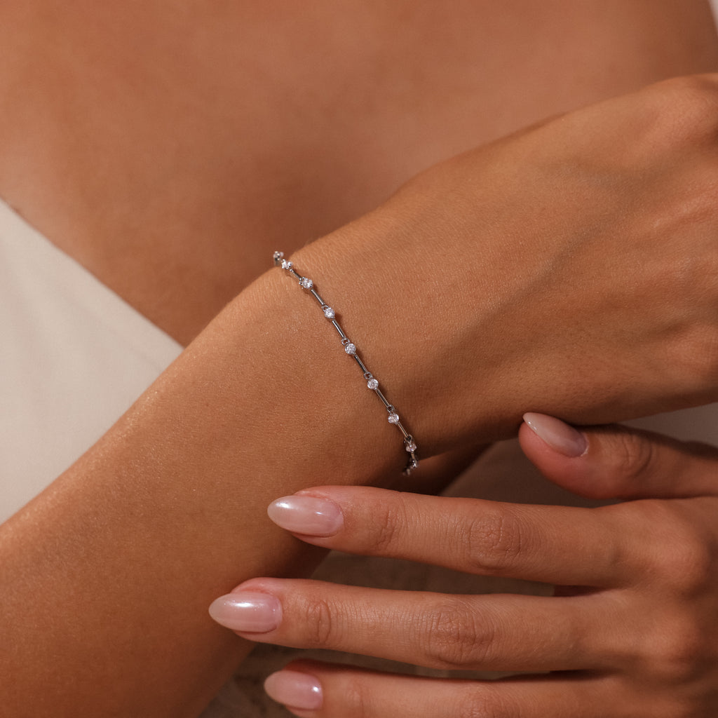 Close-up of a womans hand wearing the Sprinkle Diamond Tennis Bracelet in Silver—a delicate piece adorned with small gemstones.
