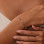 Close-up of a womans hand wearing the Sprinkle Diamond Tennis Bracelet in Silver—a delicate piece adorned with small gemstones.