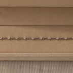 The Sprinkle Diamond Tennis Bracelet in Silver is elegantly displayed in a beige velvet jewelry box.
