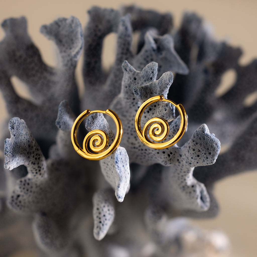Spiral Swirl Hoops displayed on textured grey coral with a soft, neutral background—ideal beachy earrings to enhance your boho vacation look.